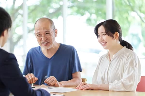 説明を受ける笑顔の女性と高齢男性